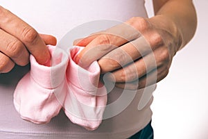 Pregnant Woman Holding Baby Socks