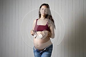 Pregnant woman holding baby socks