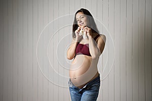 Pregnant woman holding baby socks
