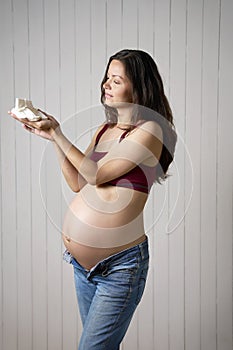 Pregnant woman holding baby socks