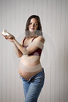 Pregnant woman holding baby socks