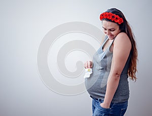 Pregnant woman holding baby socks