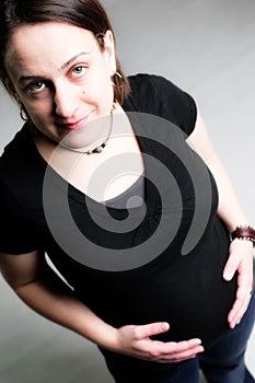 Pregnant woman holding belly and smiling