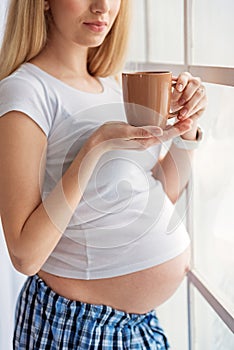 Pregnant woman holding cup of tea