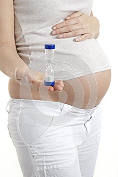 Pregnant woman holding egg timer