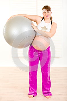 Pregnant woman holding fitness ball in hands