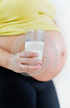 Pregnant woman holding a glass of fresh milk