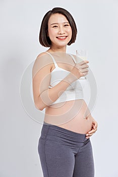 Pregnant woman holding glass of milk in her hand good healty, isolated on white background