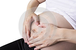 Pregnant Woman holding hand heart shape for baby in her tummy wi