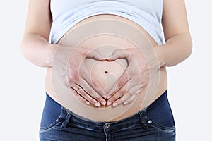 Pregnant woman holding hands in heart shape on belly, isolated o