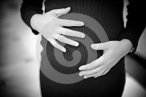 pregnant woman holding hands on her baby bump