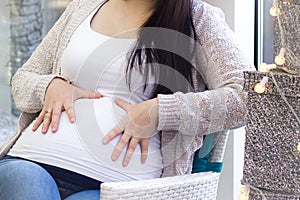 Pregnant woman holding hands on her belly