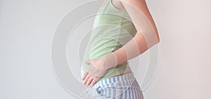 Pregnant woman holding hands on her belly. Belly of a pregnant woman on 16 week, 4 month. A woman is stroking her belly