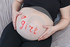 A pregnant woman holding her belly.