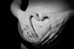 Pregnant Woman holding her hands in a heart shape