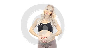 Pregnant Woman holding her hands in a heart shape on her baby bump, white