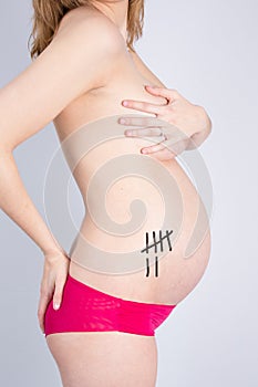 Pregnant Woman holding her hands on her body