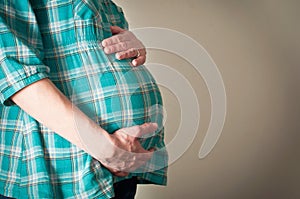 Pregnant woman holding her pregnancy bump