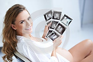 Pregnant woman holding her USG pictures
