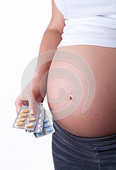 Pregnant woman holding a medical tablets