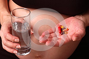 Pregnant woman holding medication