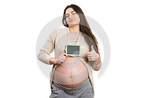 Pregnant woman holding mini blackboard and thumbs-up