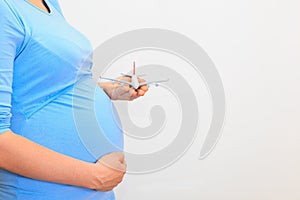 Pregnant woman holding plane model