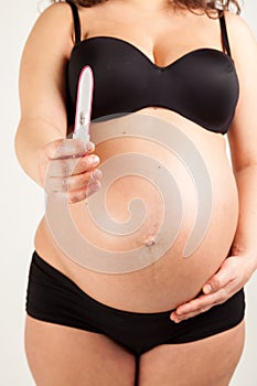 pregnant woman holding positive pregnancy test