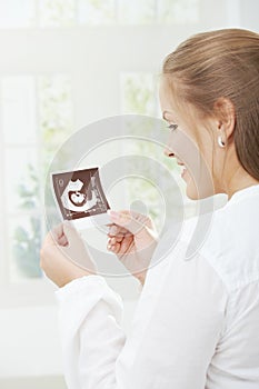 Pregnant woman holding sonogram