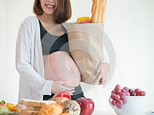 Pregnant woman holding supermarket bag