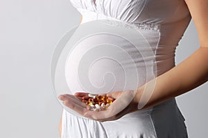 Pregnant woman holding tablets