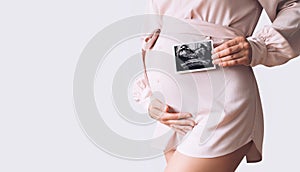 Pregnant woman holding ultrasound baby image