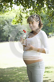 Pregnant Woman Holding Water Bottle In Park