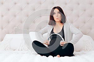 Pregnant Woman Holding Wireless Headphone on Her Belly