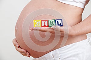 Pregnant Woman Holding Wooden Blocks Spelling Girl