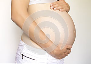 Pregnant woman holds belly
