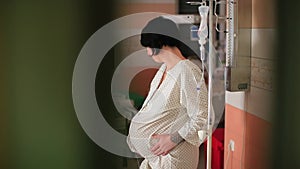 Pregnant woman holds belly with her hands contractions. Stimulation of labor.
