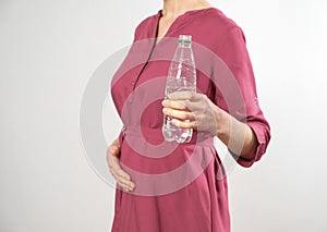 Pregnant woman holds a bottle of water