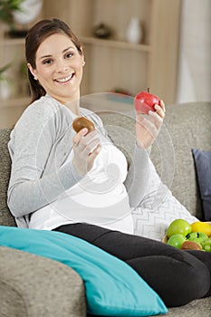 Pregnant woman holds fruits