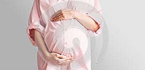 Pregnant woman holds hands on her belly. Pregnancy, maternity concept