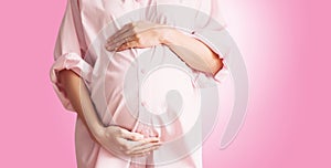 Pregnant woman holds hands on her belly. Pregnancy, maternity concept