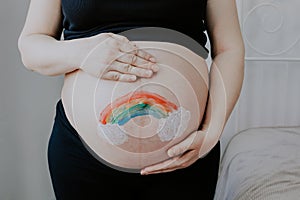 The pregnant woman holds her belly.