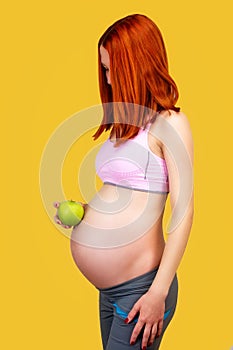 Pregnant woman holing green apple
