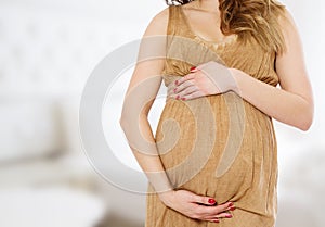Pregnant woman at home with big belly. Pregnancy and motherhood concept. Happy baby expectation. Interior and copy space. Cropped