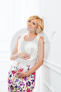 Pregnant woman hugging and looking at her stomach.