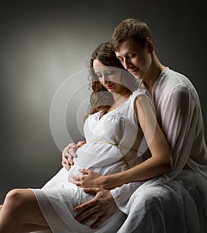 Pregnant woman with husband looking on belly