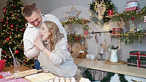 pregnant woman with husband in New Year kitchen prepare dough and eat cakes