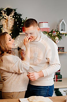 pregnant woman with husband in New Year& x27;s kitchen prepares dough and have fun