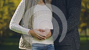 Pregnant woman with husband stroking belly, prenatal care, fertility science