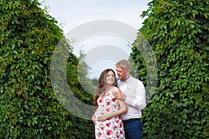 Pregnant woman with husband walking in the park